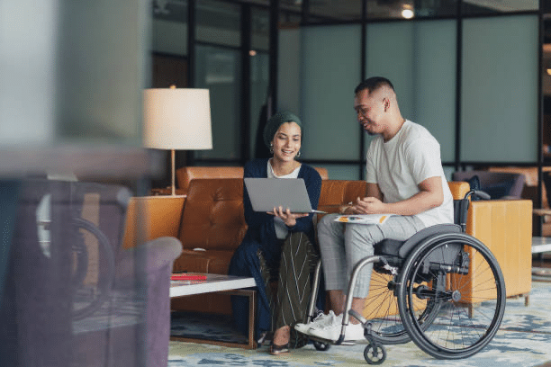 woman and man in wheelchair looking at laptop